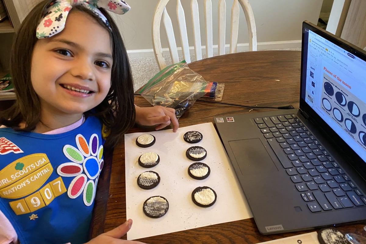 Girl Scout sitting at kitchen table with computer